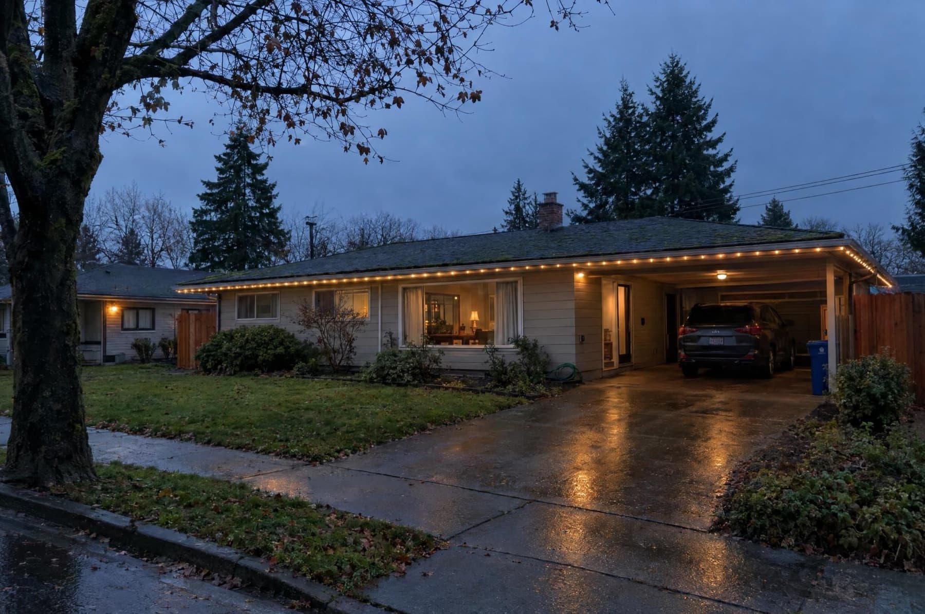 Single-story ranch with the front eave and carport lit warm white