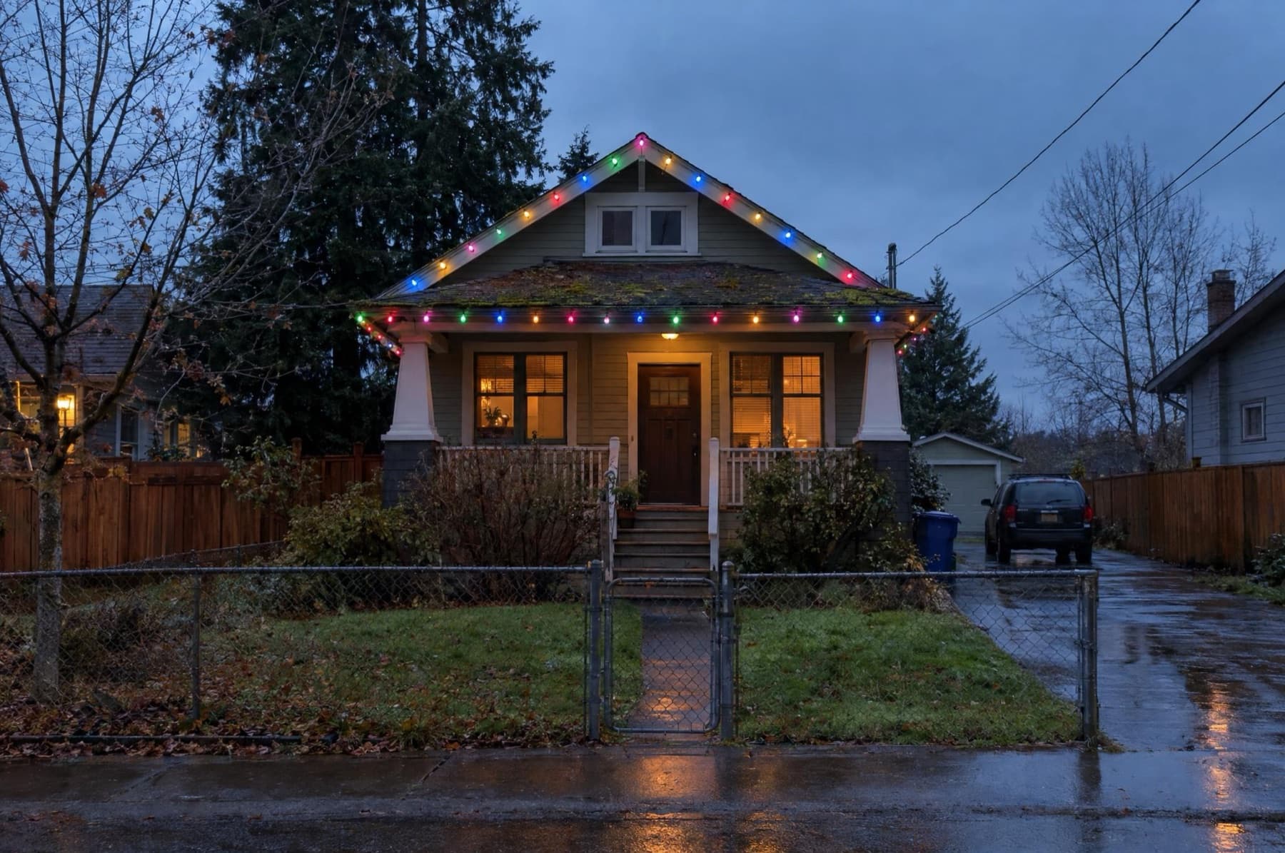 Bungalow with multicolor C9 bulbs clipped to the roof edge, green wire visible