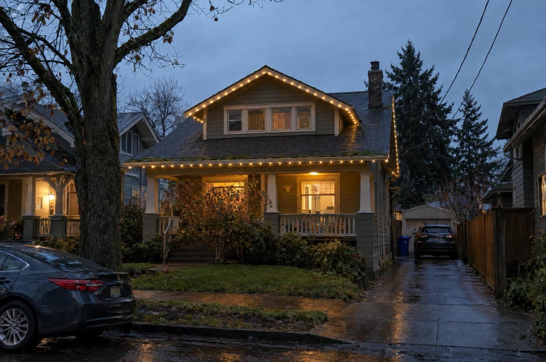 Portland craftsman bungalow with dormer and porch lit warm white on a narrow lot