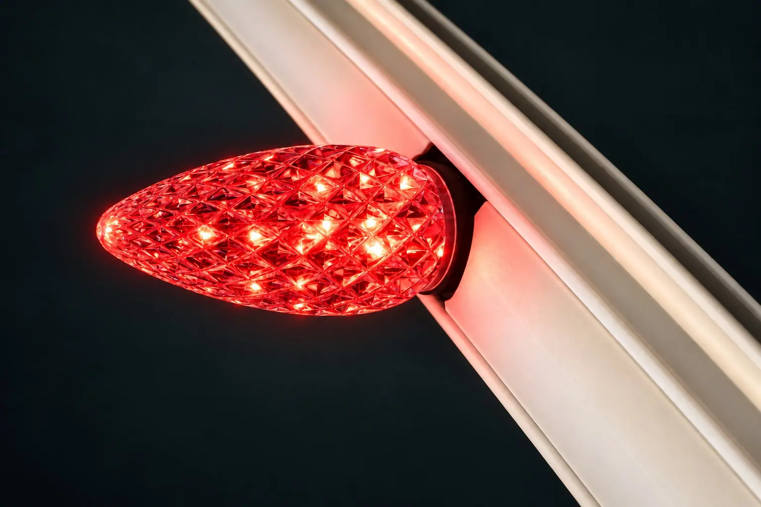 a brilliant ruby-red C9 bulb with crisp diamond facets in a permanent track
