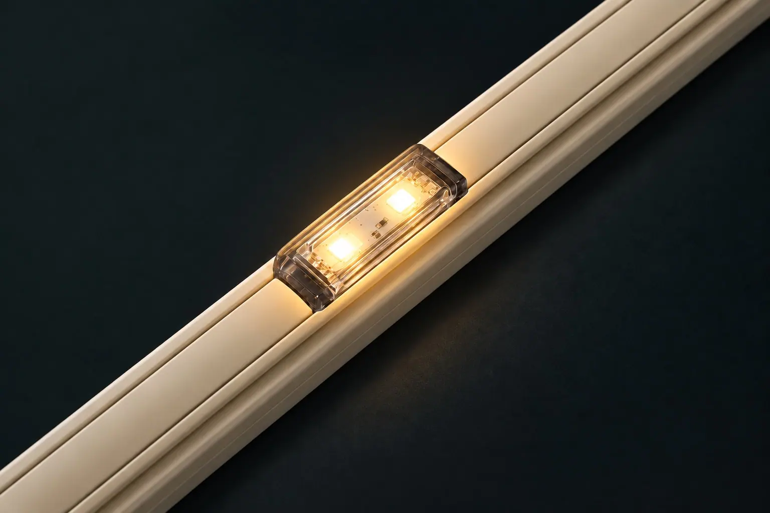 a clear dual-chip Deep Pebble lens glowing warm white and gold in a covered track